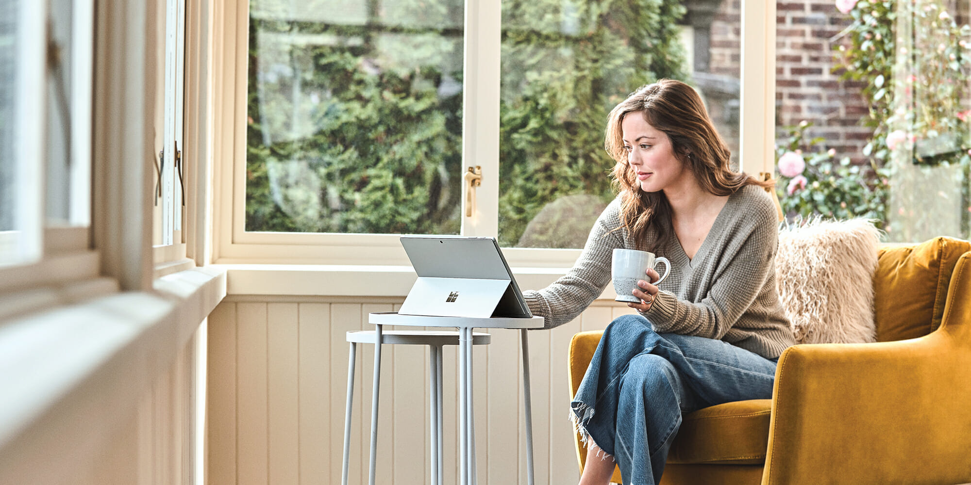 nainen istuu tuolissa puhumassa kännykällä