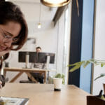 una persona sentada en una mesa frente a una ventana