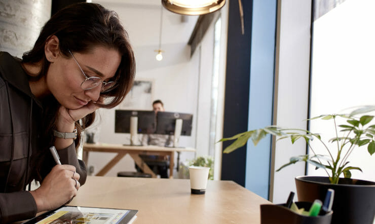 una persona sentada en una mesa frente a una ventana