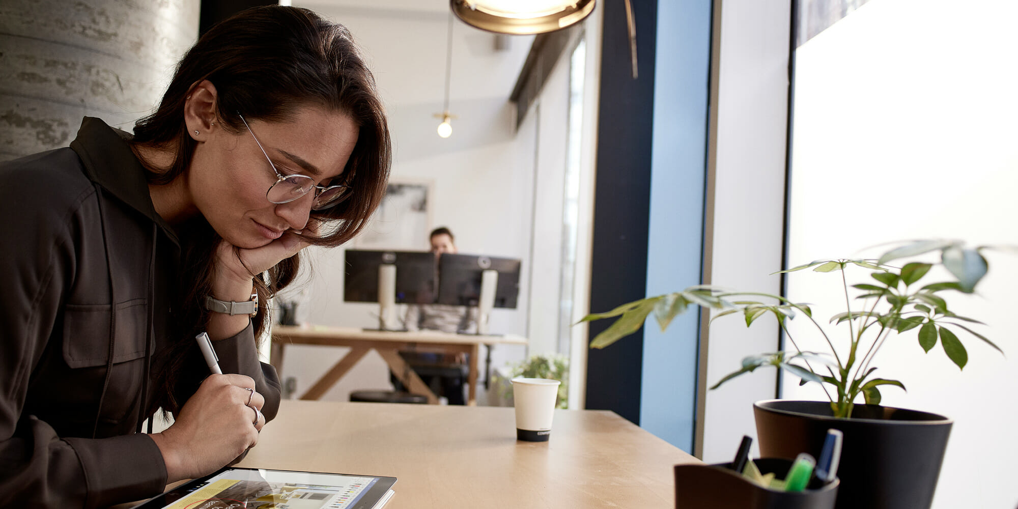 una persona sentada en una mesa frente a una ventana