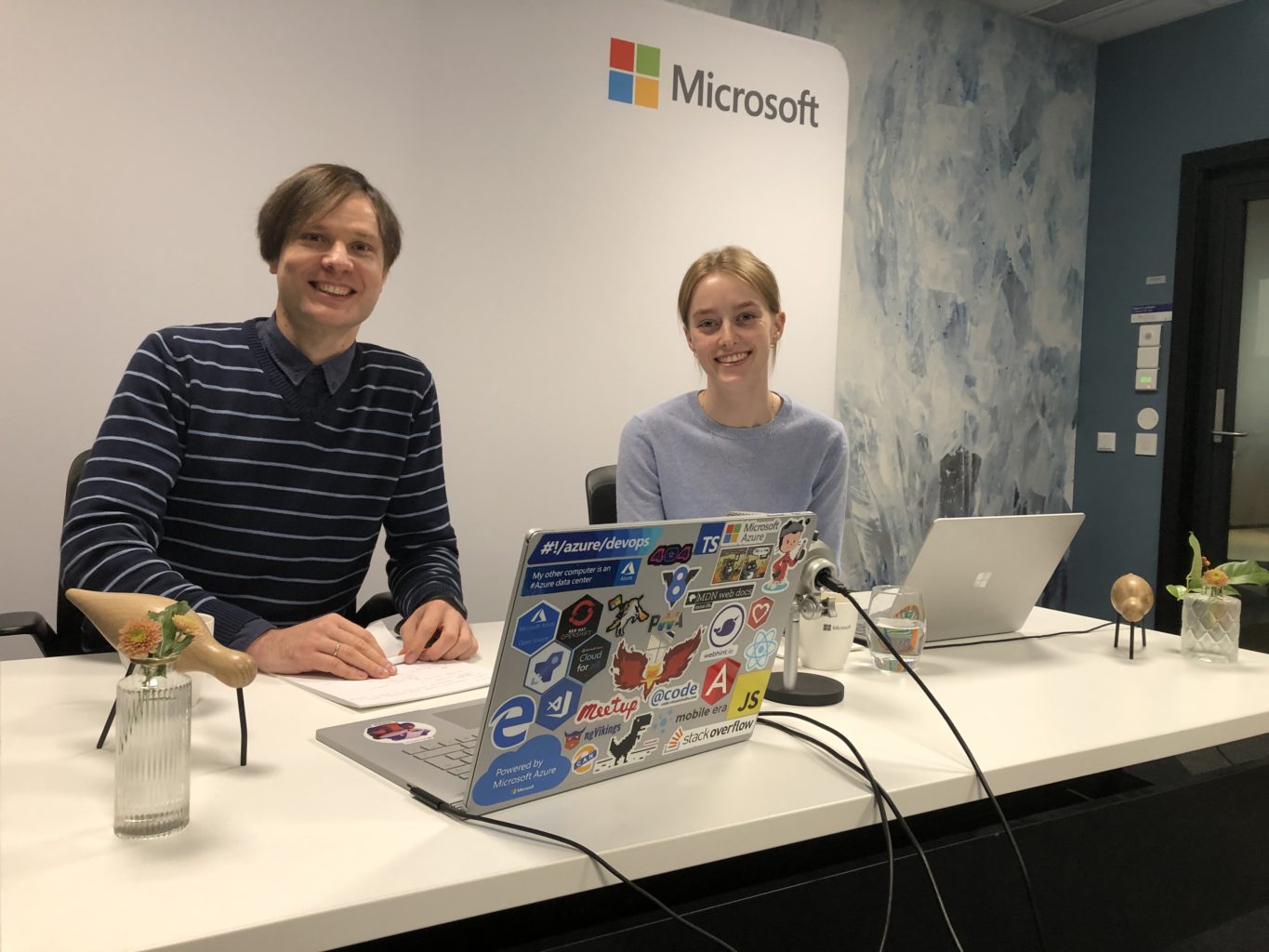 en gruppe mennesker som sitter ved et bord foran en bærbar PC