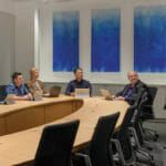 um grupo de pessoas sentadas em uma mesa em uma sala