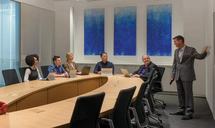 um grupo de pessoas sentadas em uma mesa em uma sala