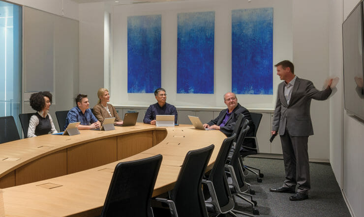 um grupo de pessoas sentadas em uma mesa em frente a uma janela