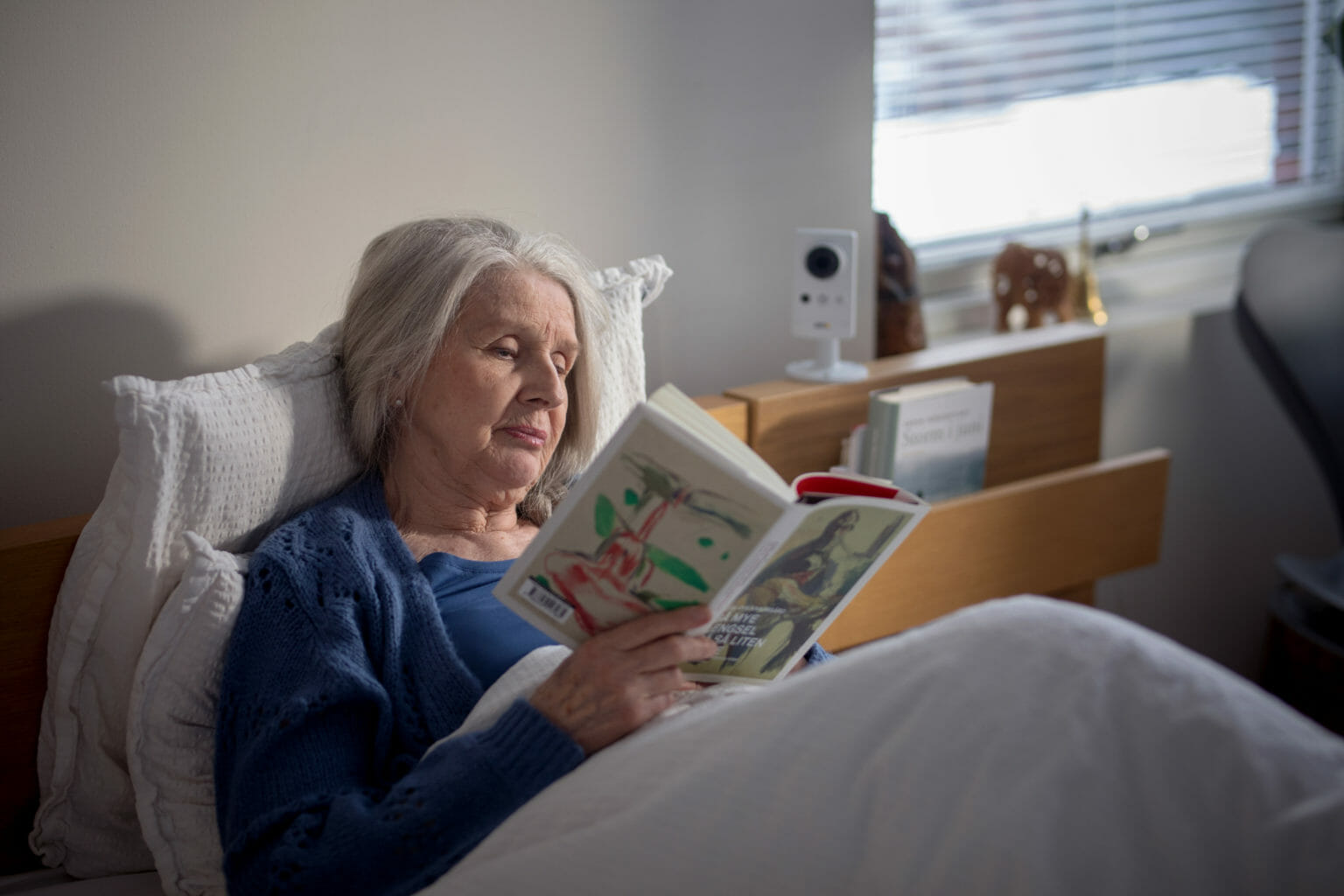 Margaret Whitlam sitter på en seng