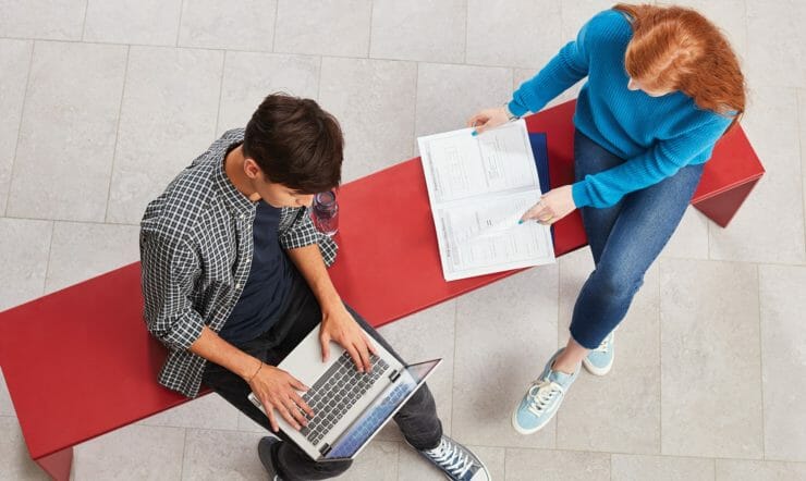 a person sitting at a table using a laptop