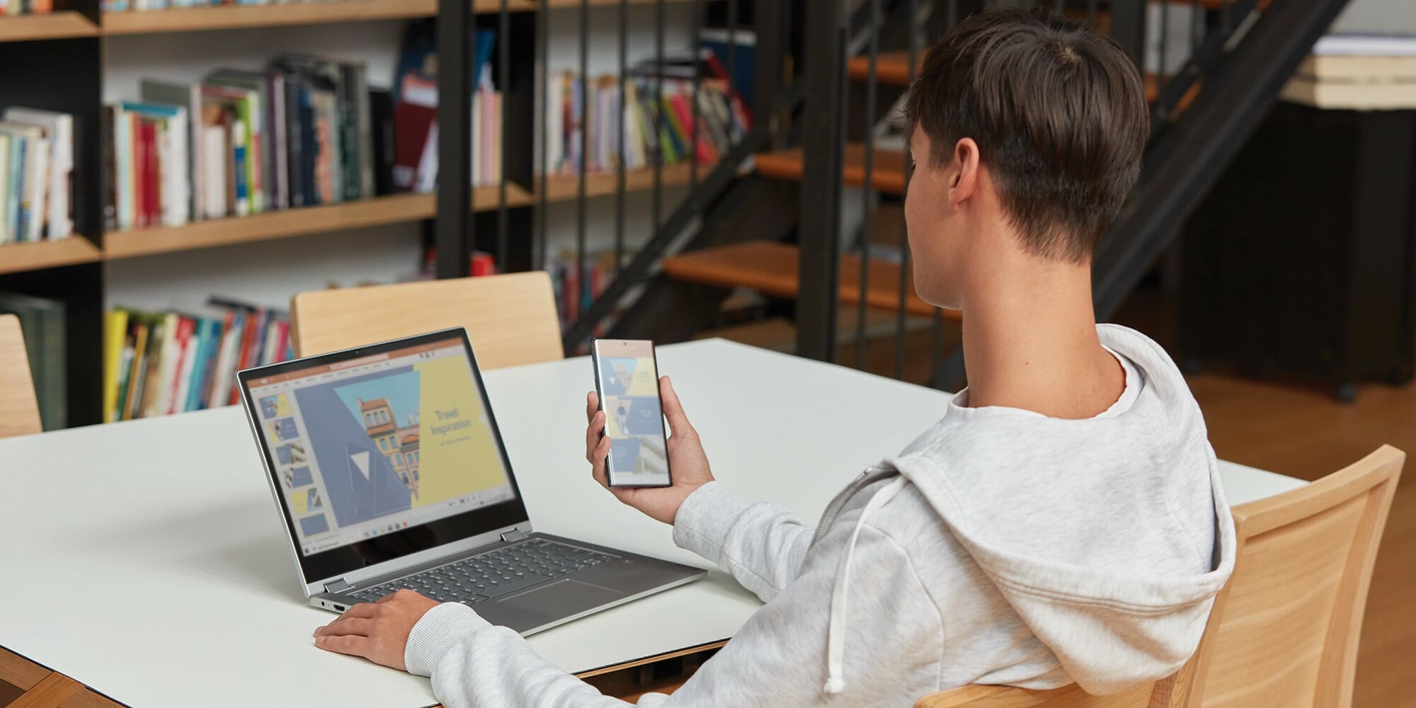 a boy using a laptop computer sitting on top of a table