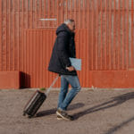 een mens die zich voor een baksteengebouw bevindt