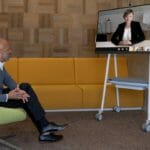 een groep mensen die aan een lijst zitten