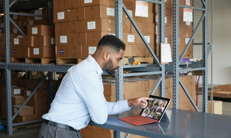 een mens die bij een lijst zit die laptop gebruikt