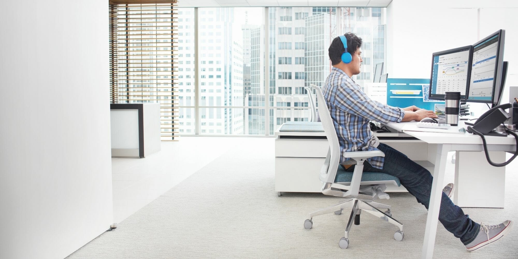 een mens die bij een bureau in een ruimte zit