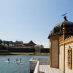 en grupp människor i en vattenmassa framför en byggnad