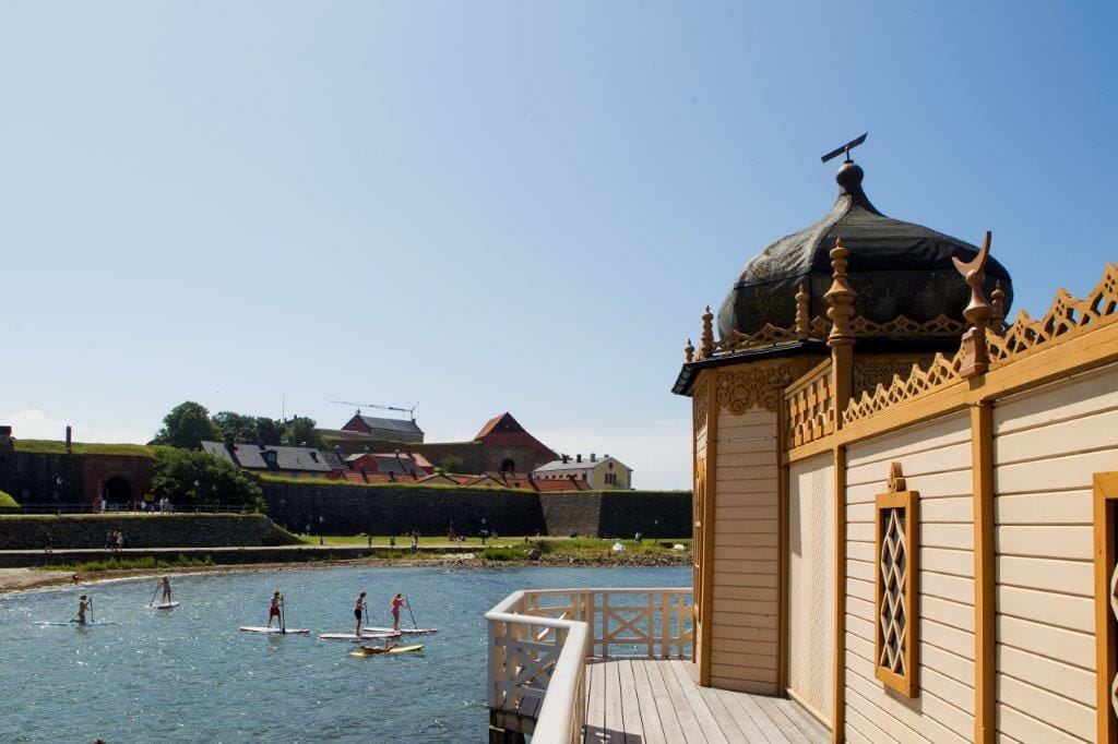 en grupp människor i en vattenmassa framför en byggnad