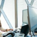 a woman sitting at a desk using a computer