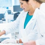 a man and a woman looking at a laptop