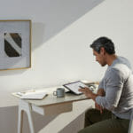 een persoon die aan een lijst met behulp van een laptop zit