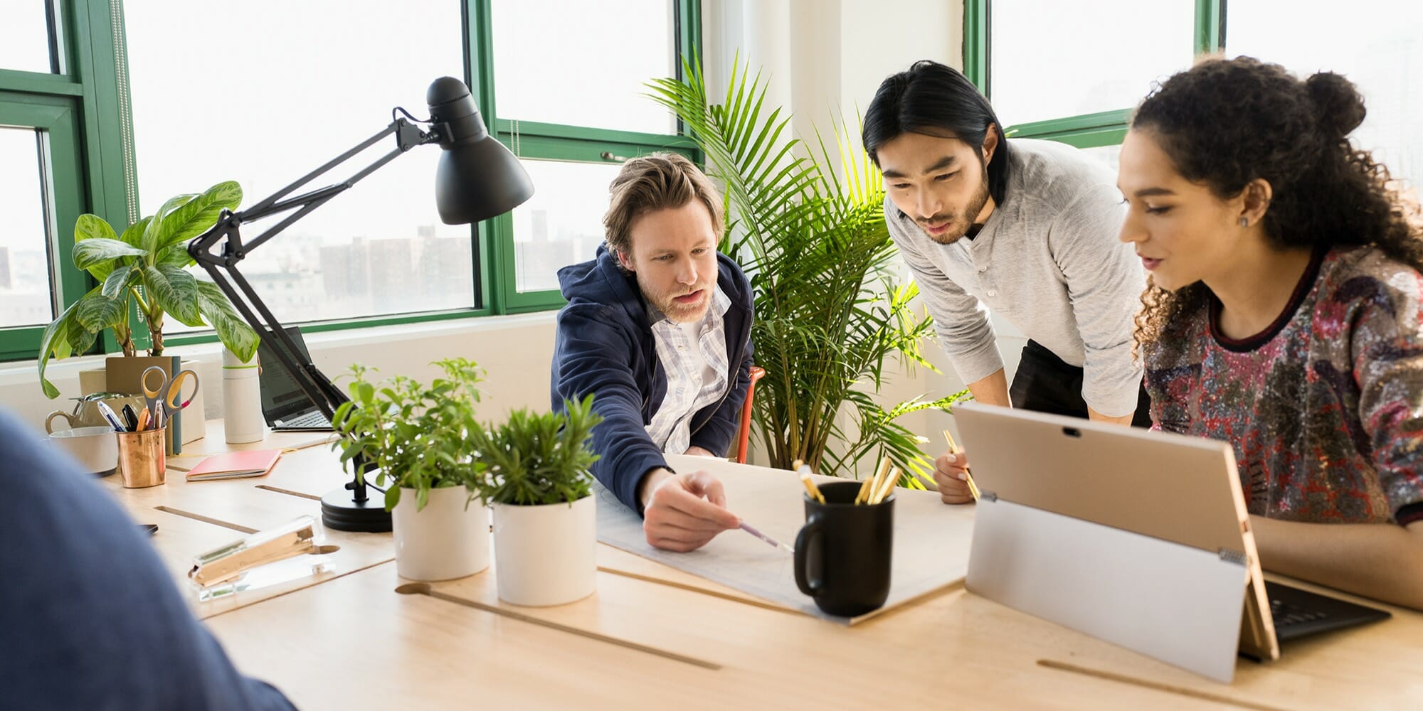 a group of people sitting at a table using a laptop computer