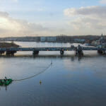 een boot die over een brug over een lichaam van water reist