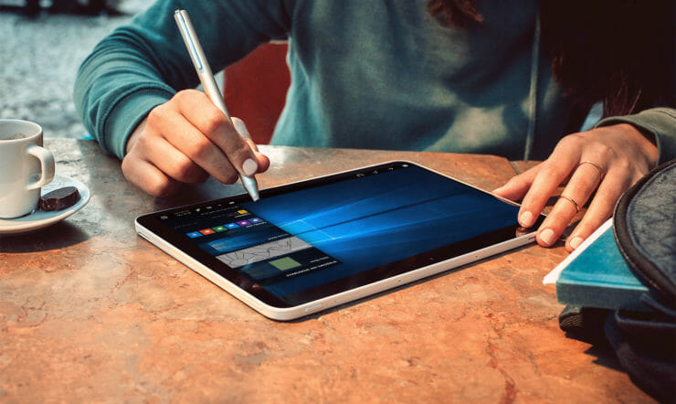 een persoon die aan een lijst met behulp van een laptop zit