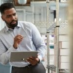 een mens met een tablet in een stockroom