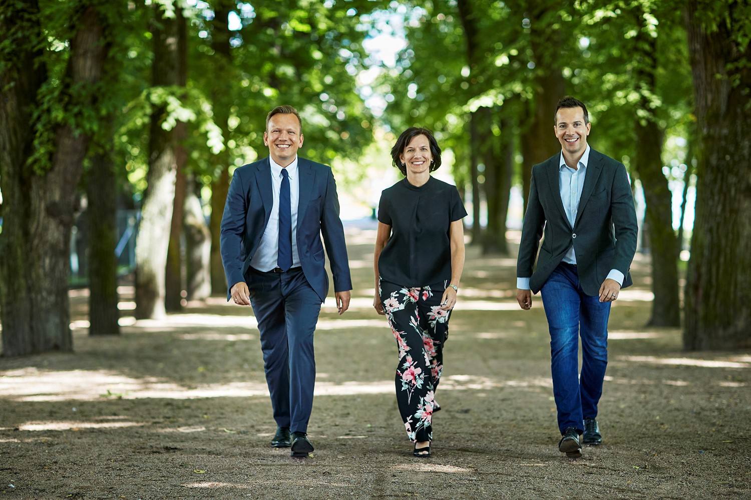 en gruppe mennesker som står ved siden av en mann i dress og slips