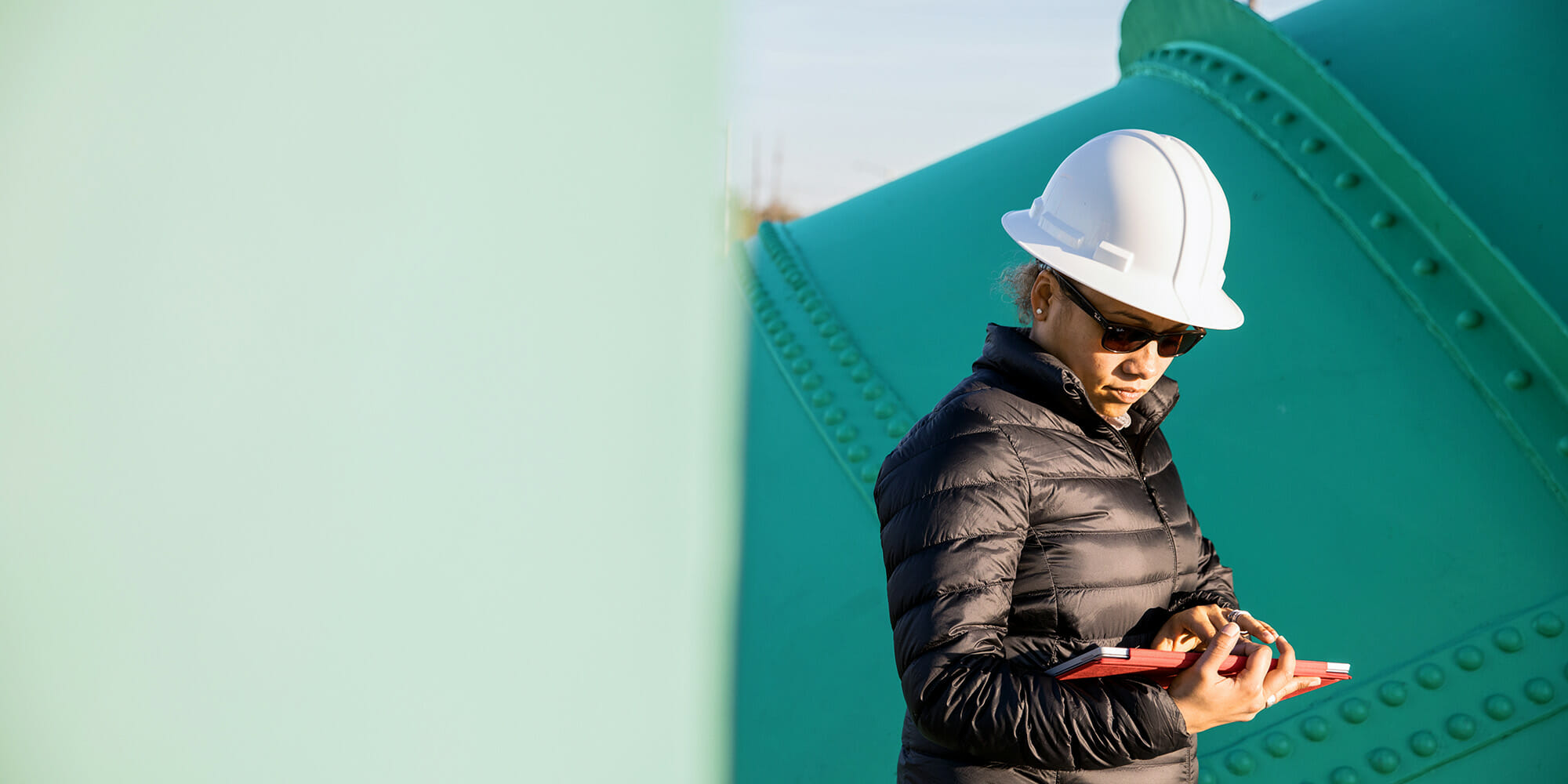 Adult woman in an industry holding a tablet