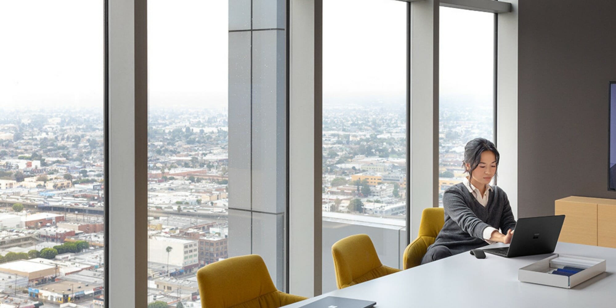 woman behind desk with skyline in background