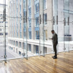 man in front of glass building