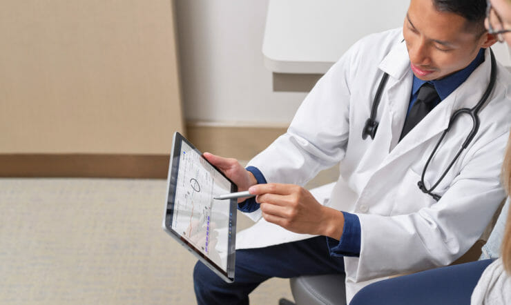Two Frontline workers pointing at Surface device with Surface pen