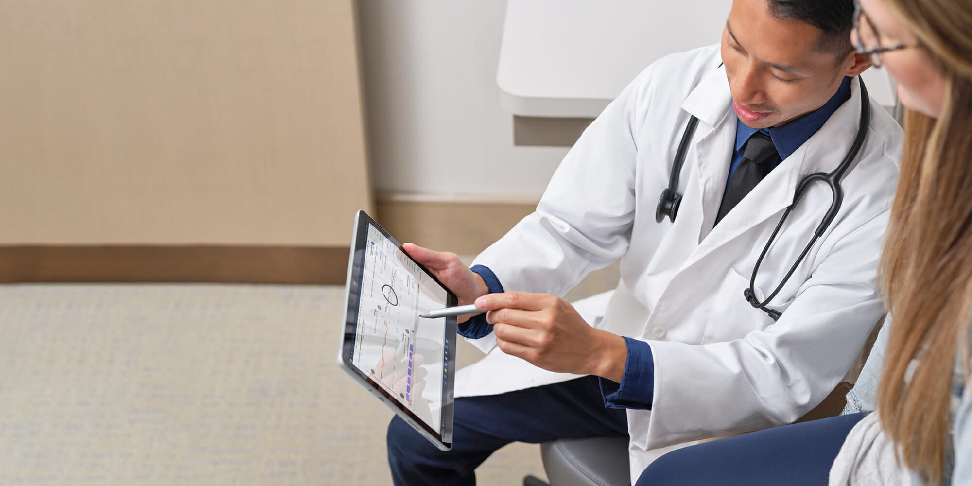 Two Frontline workers pointing at Surface device with Surface pen