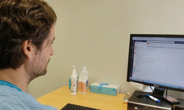 A male healthcare professional working with Microsoft Teams