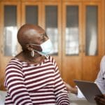 doctor and patient sitting on bed