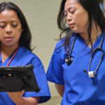 One nurse is holding a Surface Go 3 and Surface Pen while sharing the screen with another nurse.