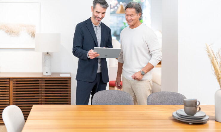 Two white male adults looking at a tablet