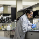 Asian female scientist working in a lab with conical flasks