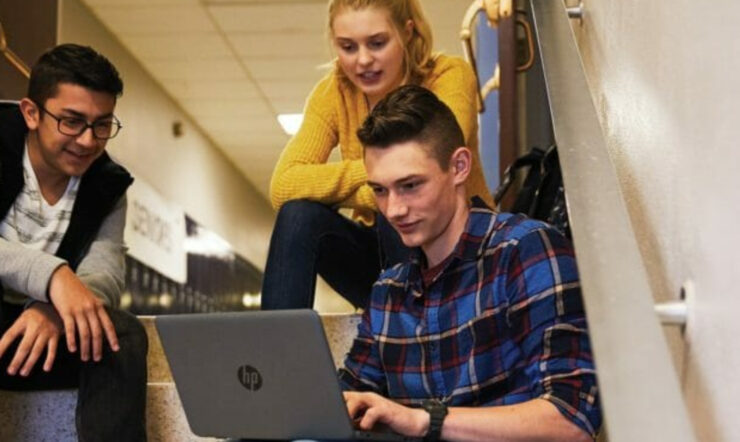 three person sitting in front of laptop