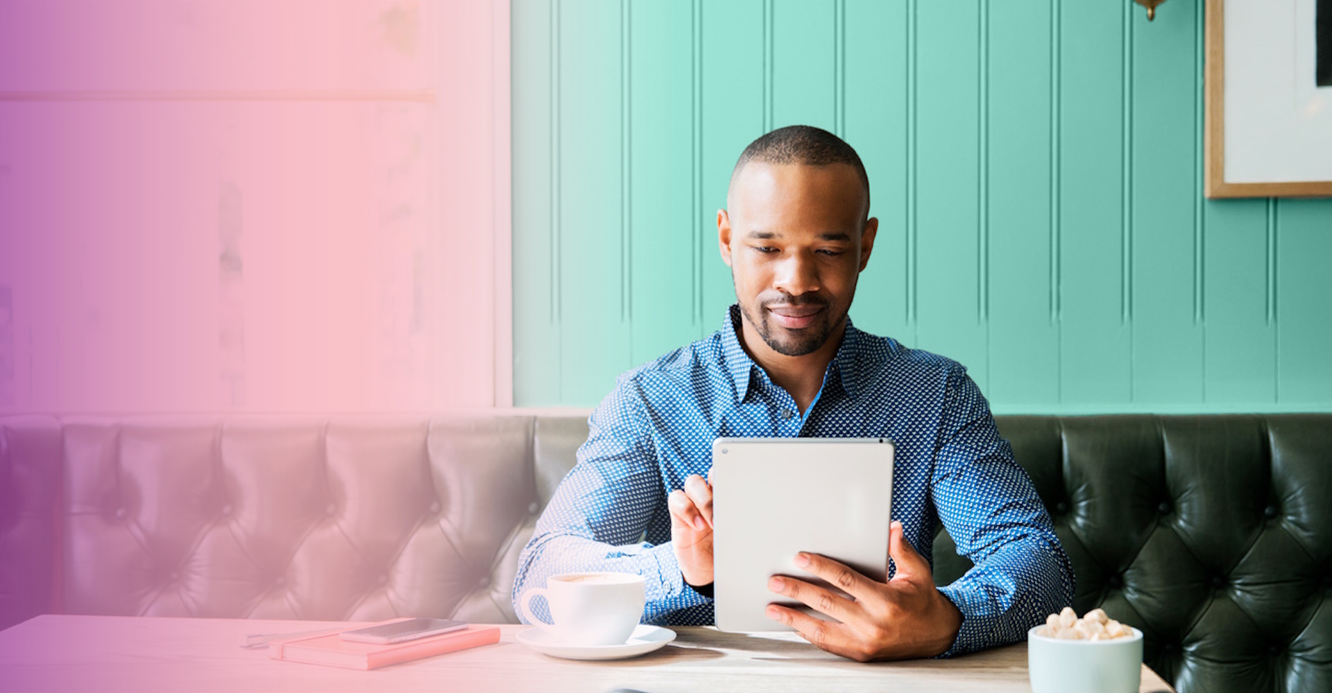 A man sitting on a sofa working with a tablet