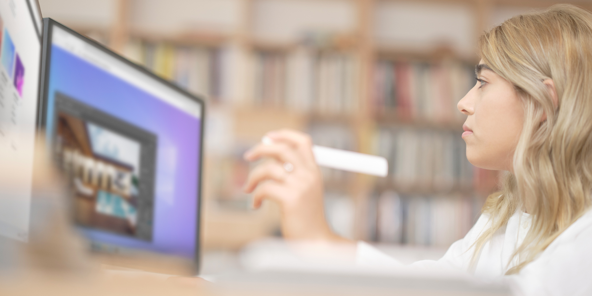Worker at a desk, looking at a computer monitor