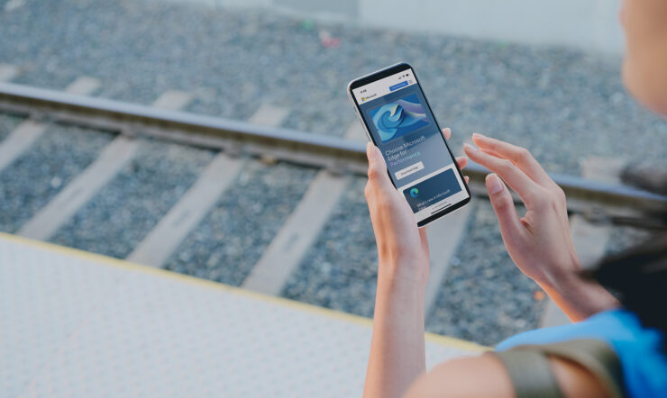 Person looking at a phone, at a train station